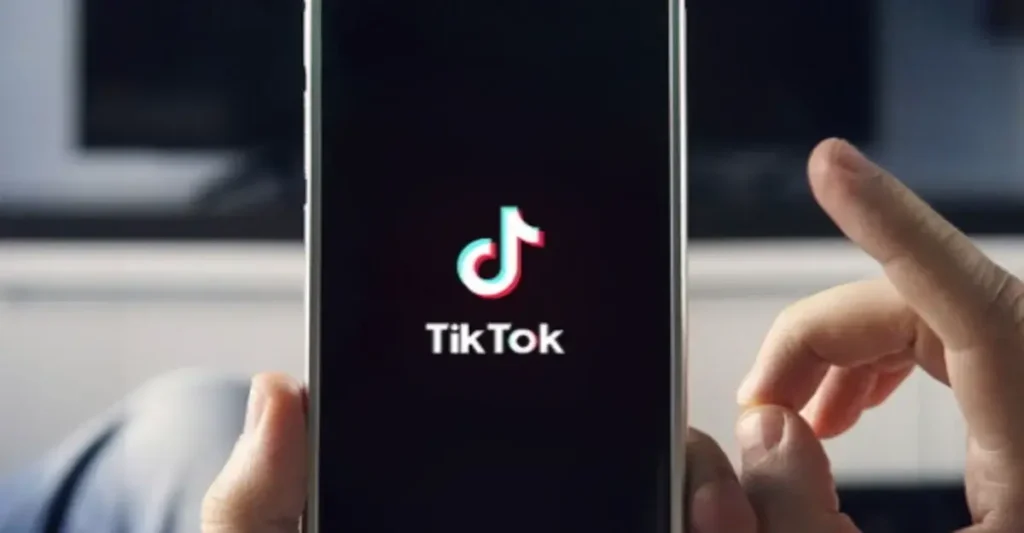 mano bianca che tiene smartphone con logo tik tok